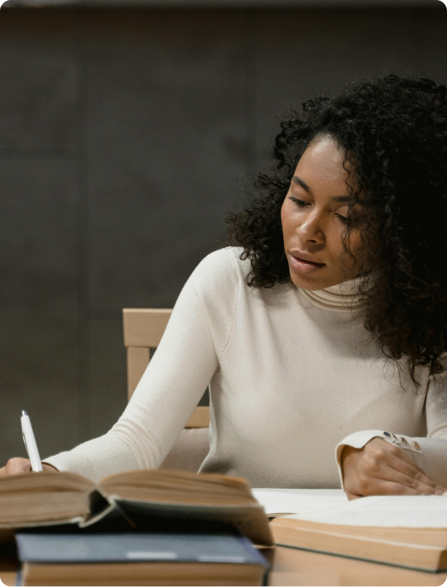 Woman sitting at a table with books